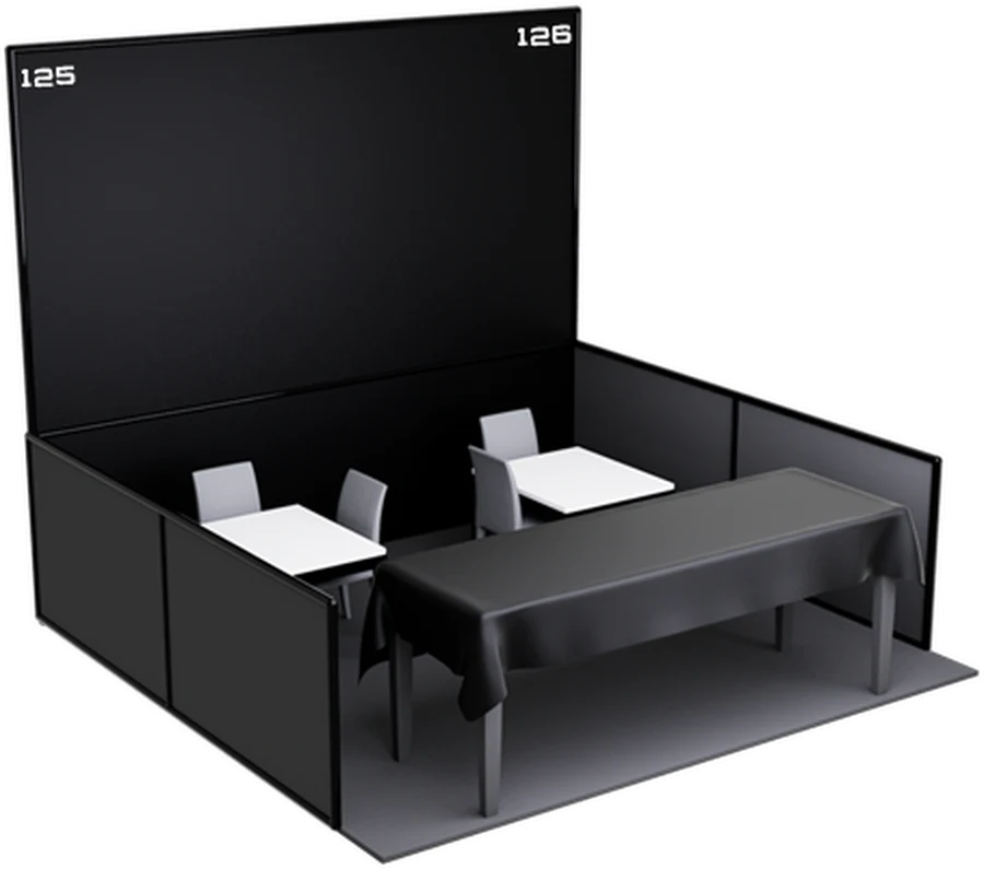 A double booth at the convention: black back and side walls, dressed tables and seating.